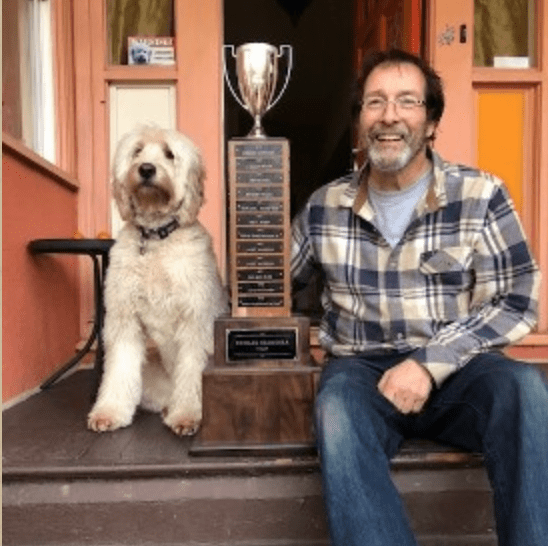 man sitting with labradoodle